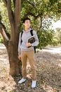 College Boy Student Standing Near the Tree while Holding a Book