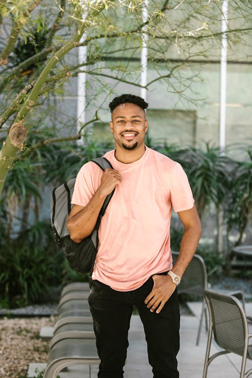 A Happy College Student Standing by a Tree