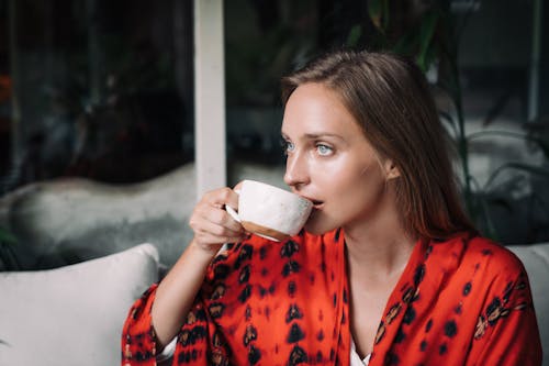 Free Woman Drinking from a Ceramic Mug Stock Photo