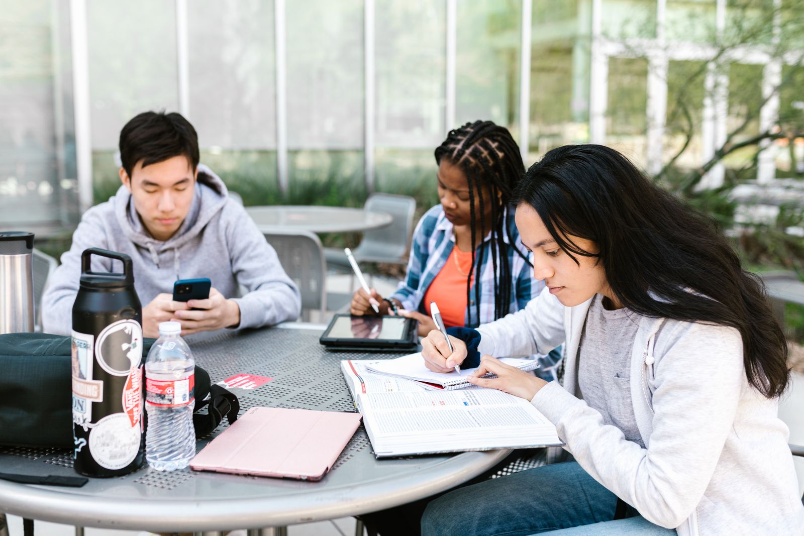 estudantes usando dispositivos digitais para pesquisa