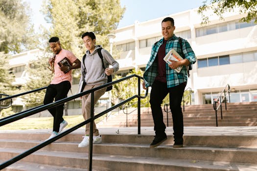 Three college students with backpacks and books on campus stairs outdoors.