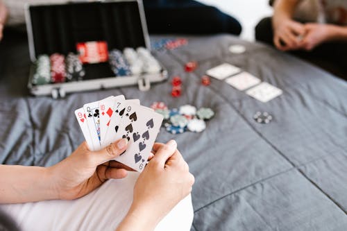 People Playing Poker at the Bed