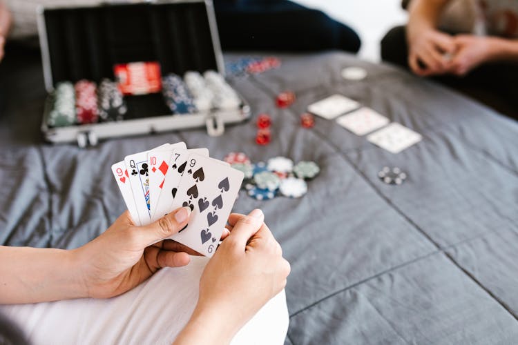 People Playing Poker At The Bed