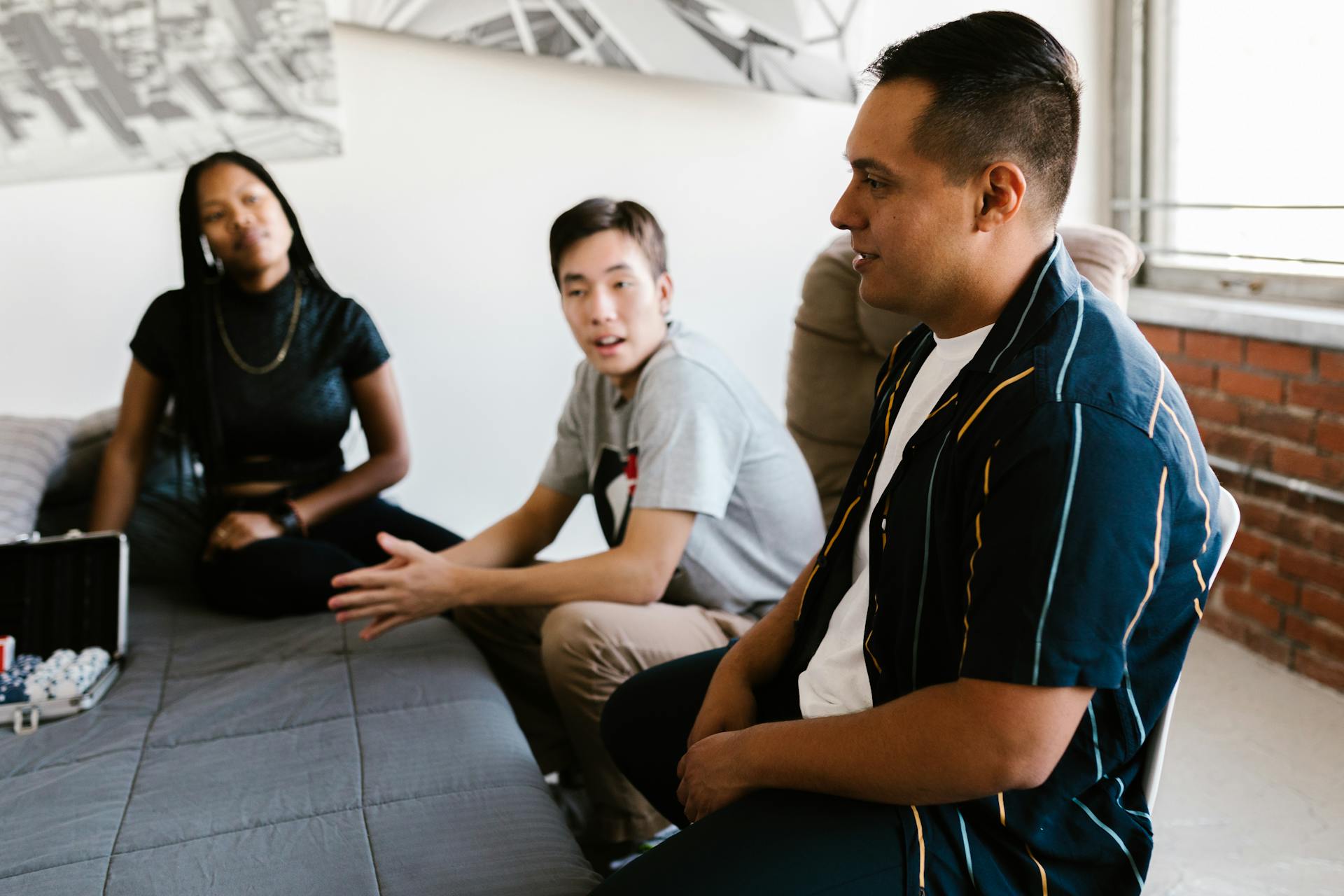 Students hanging out in a cozy dorm room, discussing and enjoying time together.