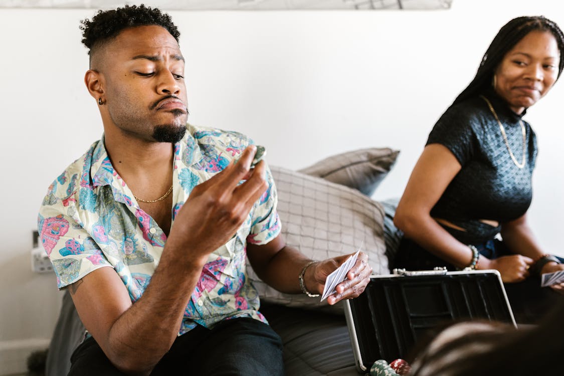 Free Man in Printed Shirt Holding Poker Chips and Playing Cards Stock Photo