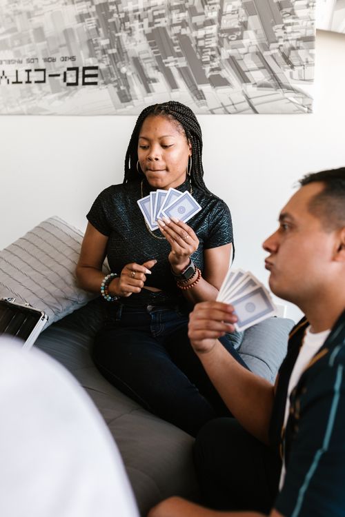 Free Two adults enjoy a card game in a relaxed indoor environment. Stock Photo