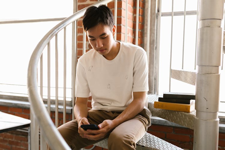 Man In White Crew Neck T-shirt Sitting On The Stairs