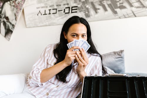 Woman in Striped Long Sleeve Shirt Holding Playing Cards