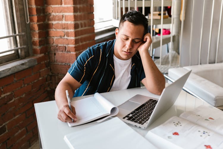 A Young College Student That Has Fallen Asleep While Studying