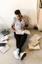 A Young Man Reading a Book while Sitting on the Floor