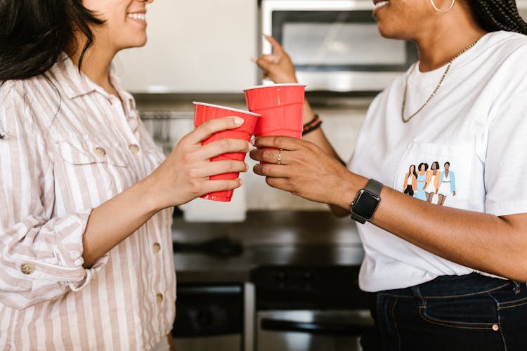 Women Holding Red Plastic Cups