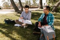 Men Sitting on the Grass Field While Studying