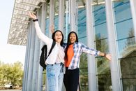 Woman in Blue Denim Jeans Standing Beside Woman in White and Blue Plaid Long Sleeve Shirt