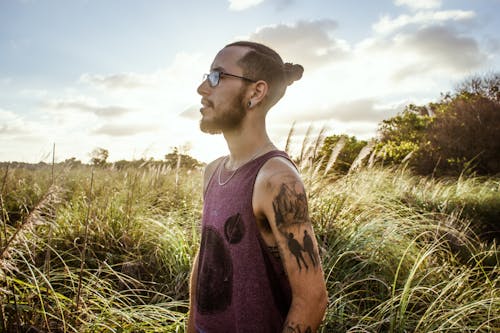Free 
A Bearded Tattooed Man on a Field Stock Photo