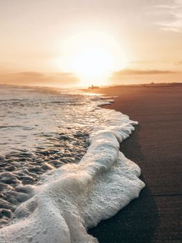 Golden sunset over a serene beach with gentle waves, perfect for nature lovers seeking tranquility.