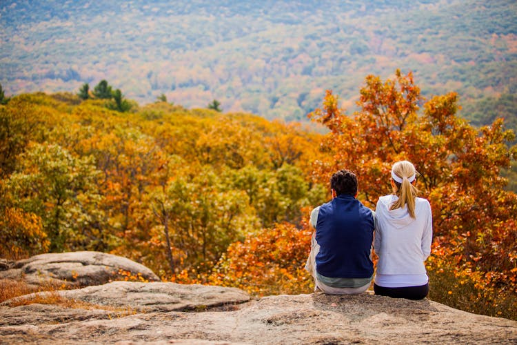 Couple Sitting On Mountain Top