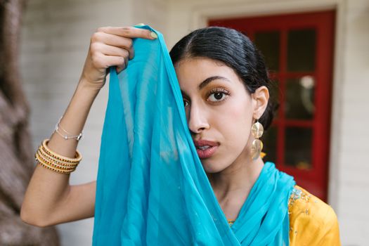 Woman in Blue and Yellow Sari Holding Her Hair