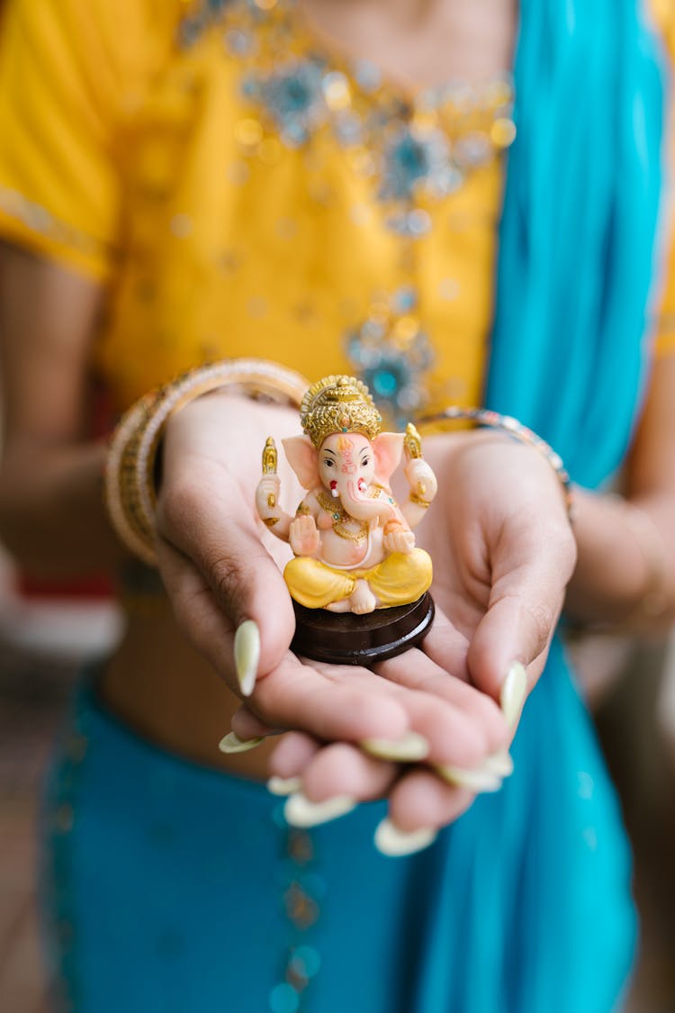 A Woman Holding A Ganesha Figurine