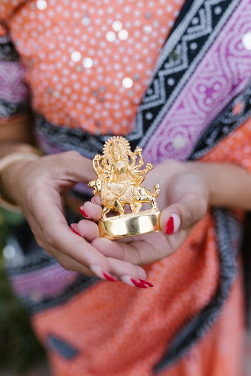 Free Woman Holding a Golden Figurine Stock Photo