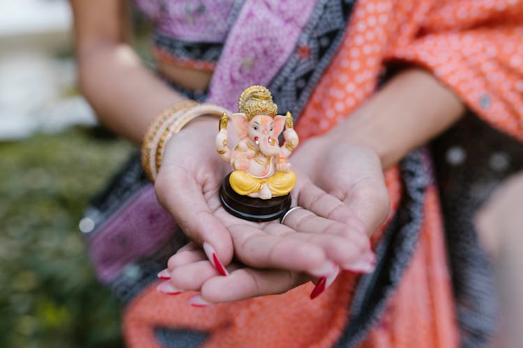 Person Holding An Elephant Figurine