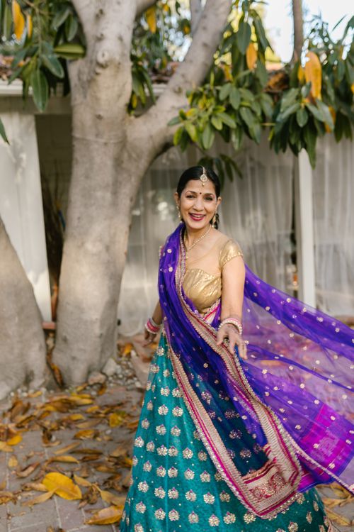 Free A joyful Indian woman in a colorful saree smiling outdoors. Stock Photo
