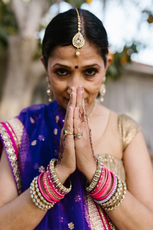 Free A South Asian woman in traditional attire performing the Namaste gesture, outdoors. Stock Photo