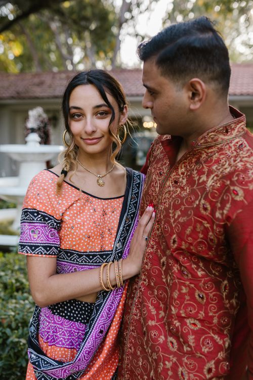 Free A couple embracing outdoors in colorful traditional Indian outfits and smiling. Stock Photo