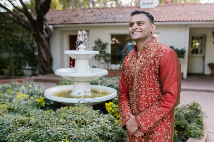 Smiling Man Beside A Water Fountain