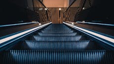 一台时尚的现代自动扶梯，以独特的向上视角拍摄，两侧散发着光芒