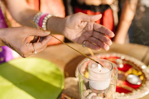 Free Close-up of hands lighting a candle during a Diwali festival ceremony, creating a warm and festive atmosphere. Stock Photo