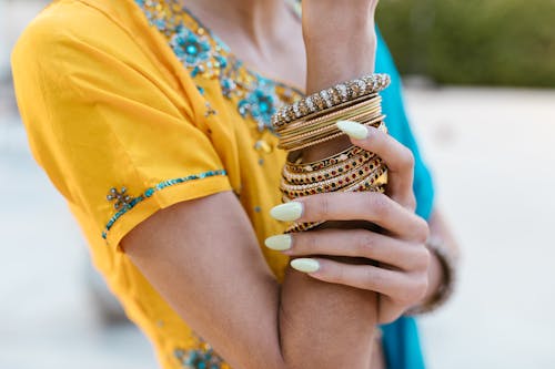 Manicured Nails of a Holding Arm With Gold Bracelets