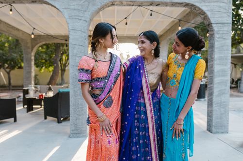 Free A joyful moment of three Indian women in colorful traditional sarees sharing love and togetherness outdoors. Stock Photo
