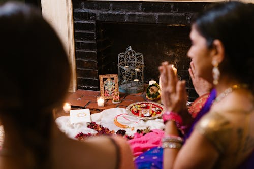 Women Praying in front of a Hindu Deity Figurine 