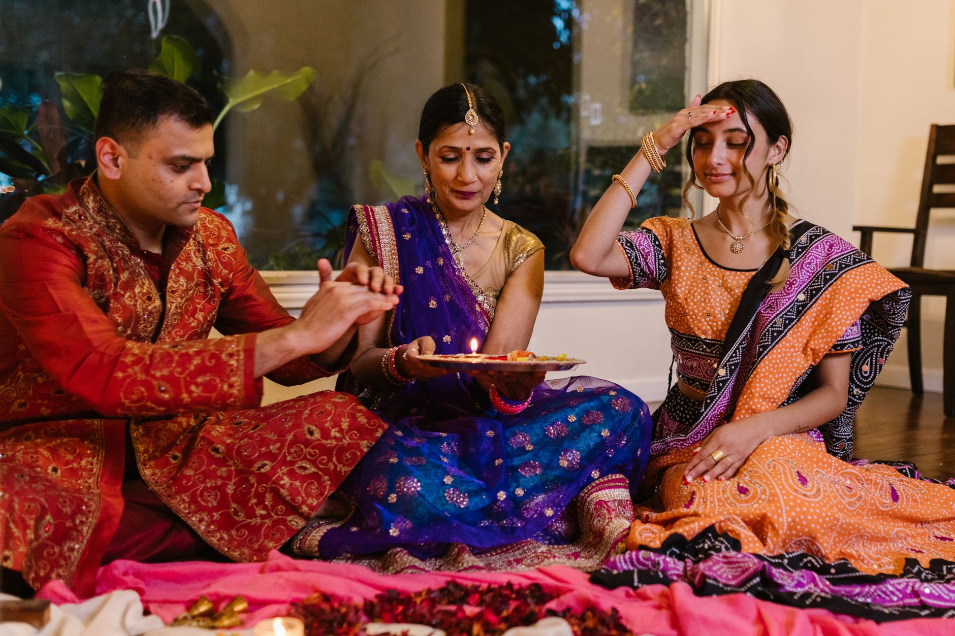 A family engaged in Diwali celebrations with traditional attire and rituals, showcasing rich Indian culture.