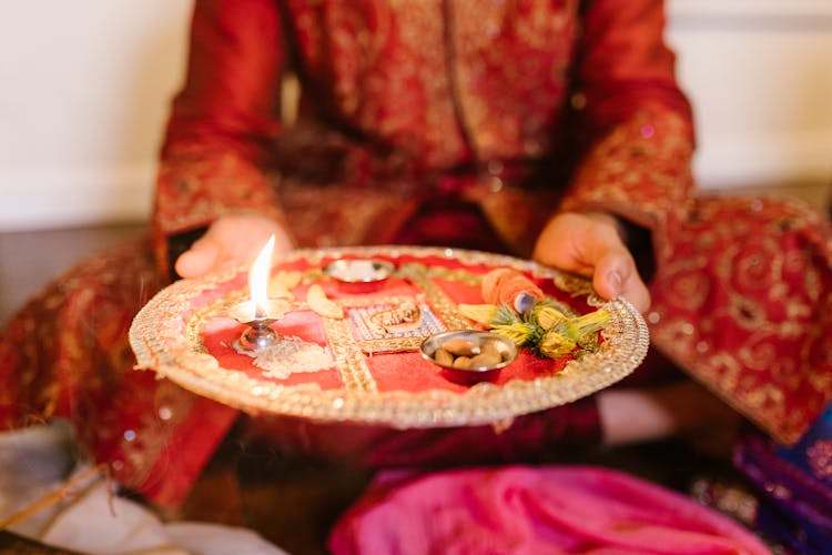 A Man Holding A Puja Thali