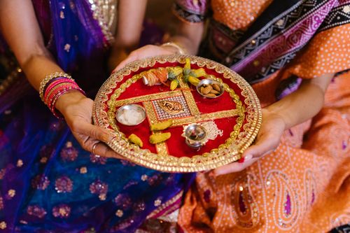 Free Women holding a decorative tray with traditional Indian ceremonial items. Stock Photo