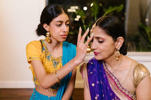 A Young Woman Touching her Mother's Forehead