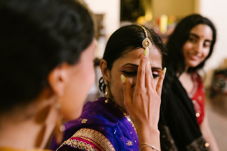 A Woman Touching Another Woman's Forehead