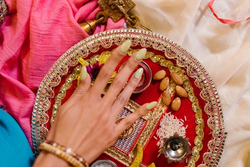 
A Close-Up Shot of a Hand over a Tray with Items for Worship