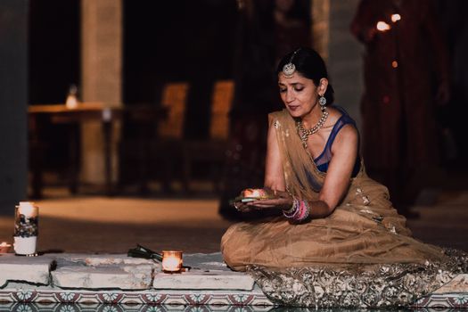 Woman Putting Flowers on Water at Diwali Celebration