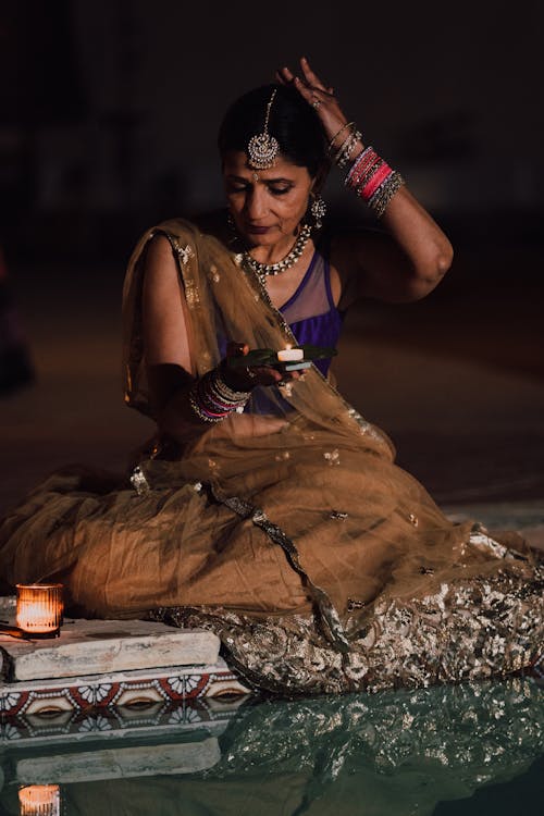 Free A Woman in a Traditional Clothing Holding a Candle Stock Photo