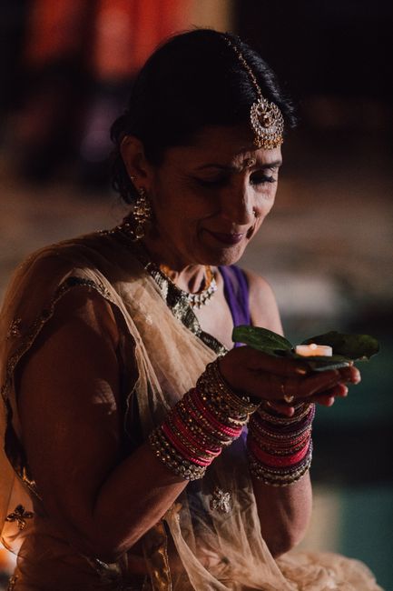 Senior woman in traditional Indian attire holding a candle during Diwali celebration.