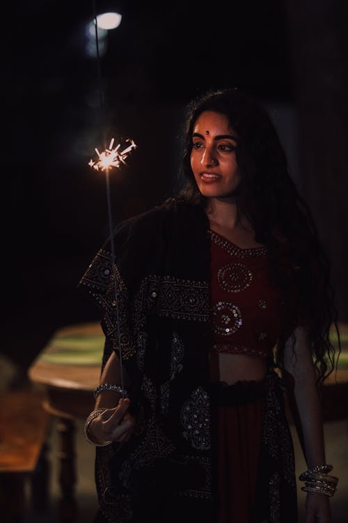 Woman in Traditional Dress Holding Sparkler