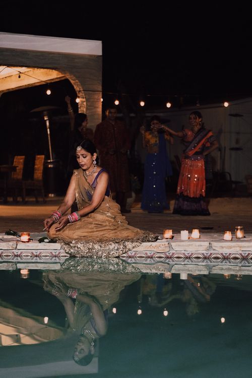 Free A woman in traditional Indian attire celebrating Diwali by the poolside with candles and reflections. Stock Photo
