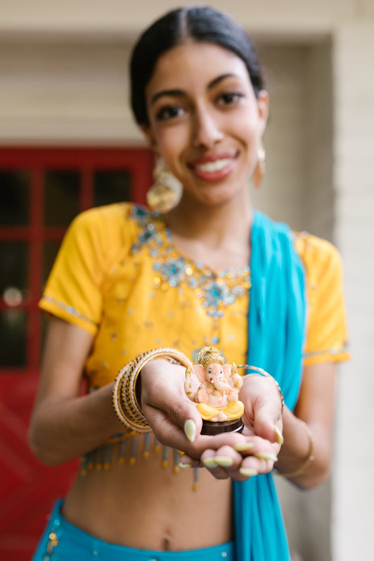 A Woman Holding A Ganesha Figurine