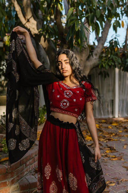Woman in Red Crop Top and Red Pants Holding Black Scarf