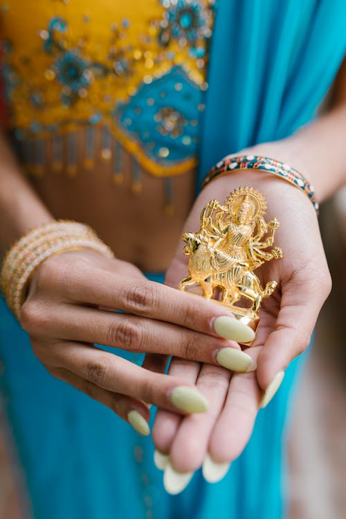 Free Person Holding a Golden Durga Statue Stock Photo