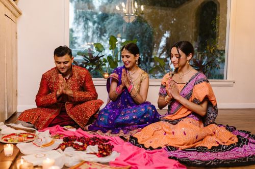 Free Family celebrating Diwali with prayer, candles, and traditional clothing indoors. Stock Photo
