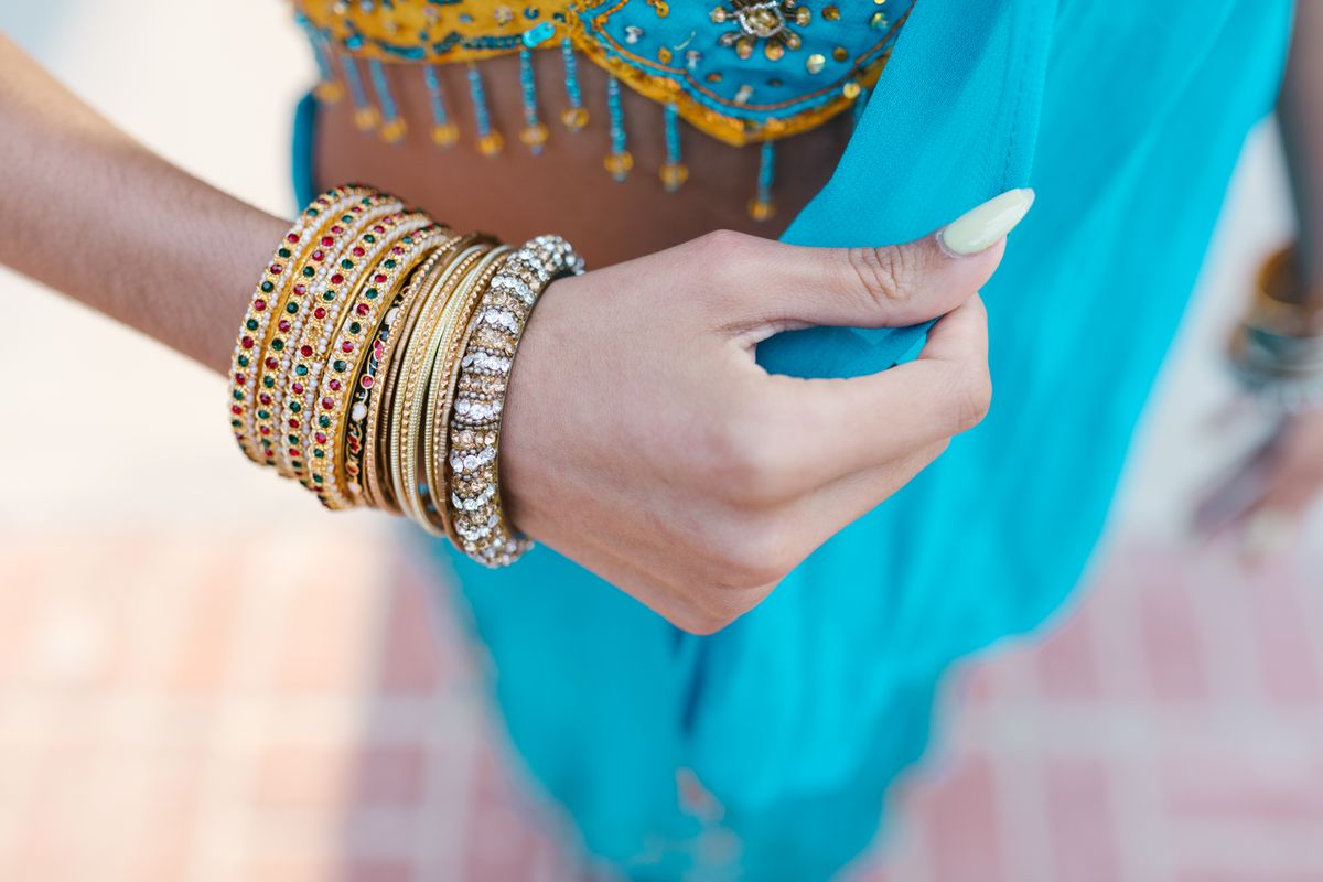 A wrist stacked with colorful bangle bracelets