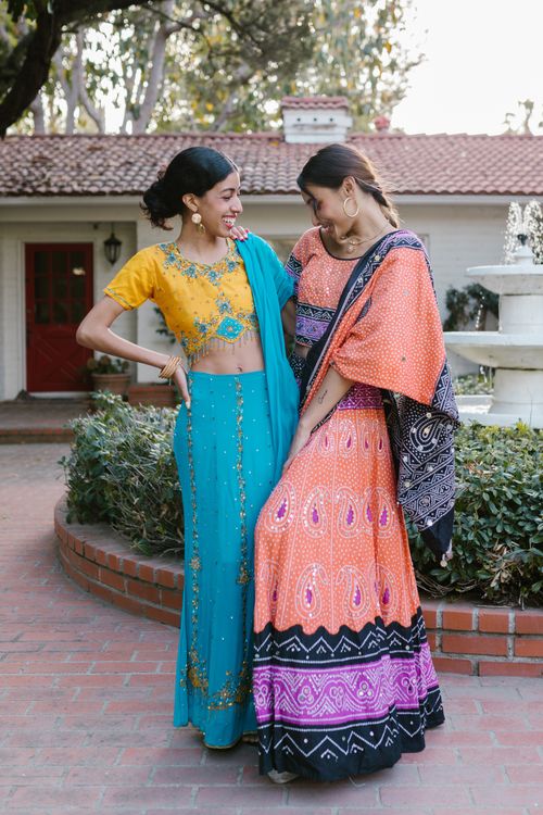 Free Two women smiling in colorful saris outdoors, celebrating in traditional styles. Stock Photo